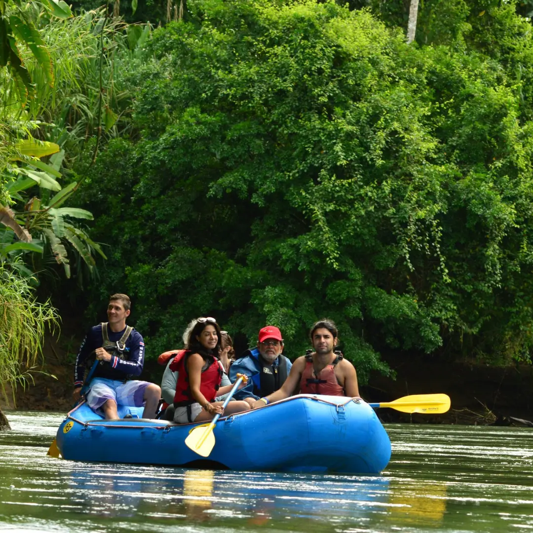Travelers on a peaceful river float tour with Wave Rafting surrounded by tropical rainforest