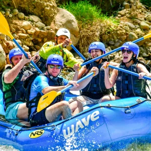 Smiling group rafting through whitewater rapids with Wave Rafting Costa Rica