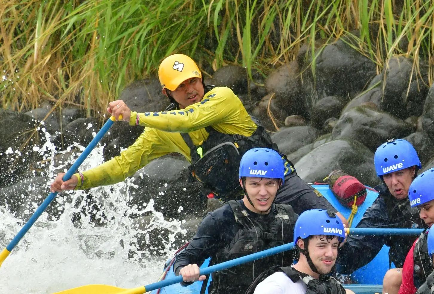 Wave rafting guide steering group through rapids in Costa Rica